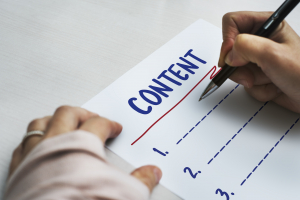 tangan menulis dengan pena di atas kertas berjudul content