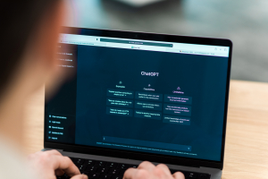 seorang pria sedang membuka laptop dengan tampila open ai chatgpt
